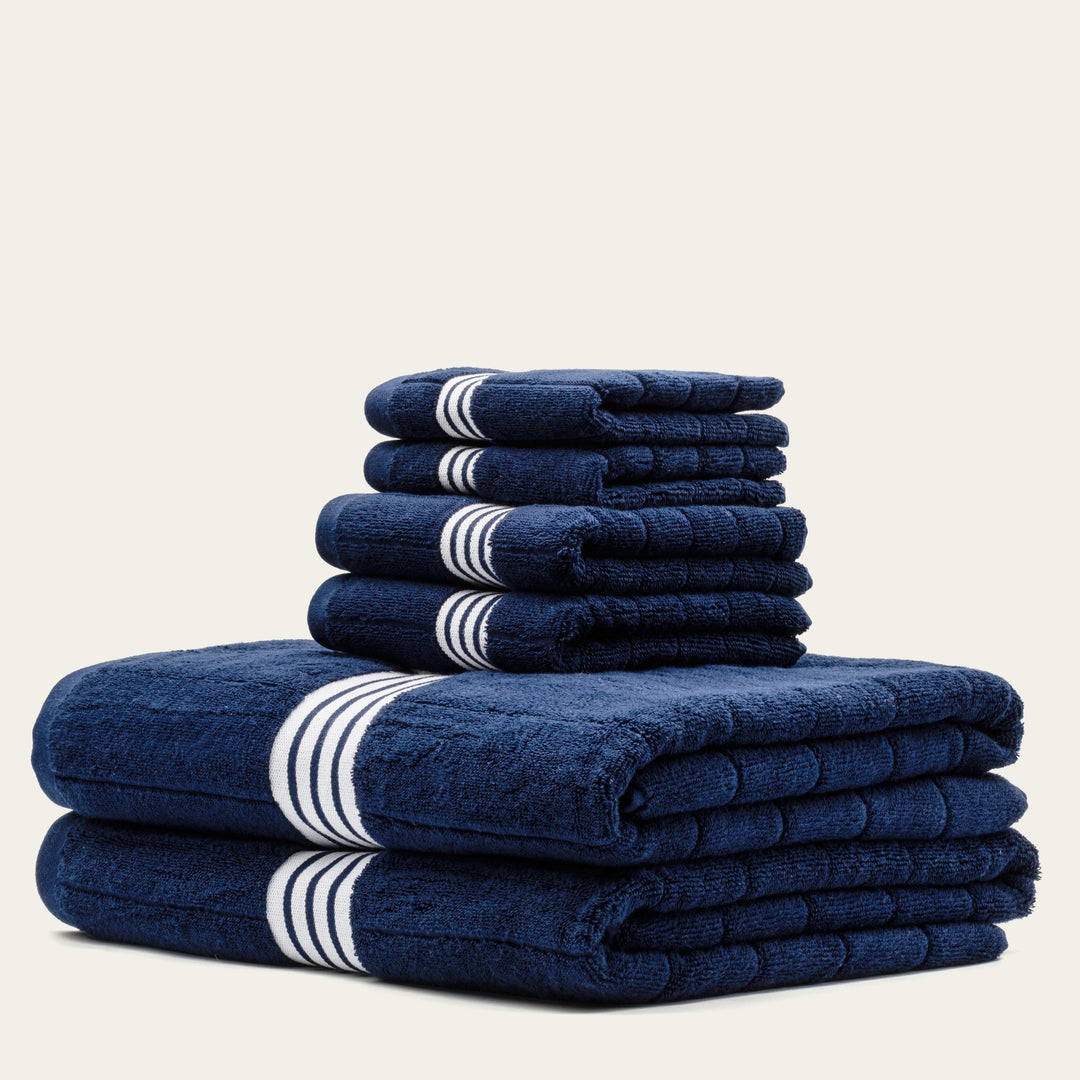 Navy cotton towels with white striped bands, folded stack of 4 towels