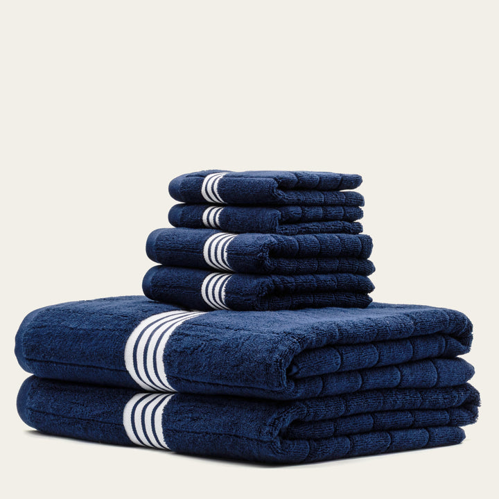 Navy cotton towels with white striped bands, folded stack of 4 towels