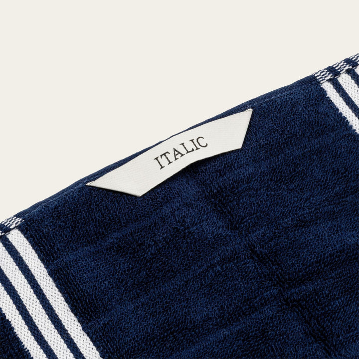 Navy cotton towel corner tag with “ITALIC” text and white stripe trim