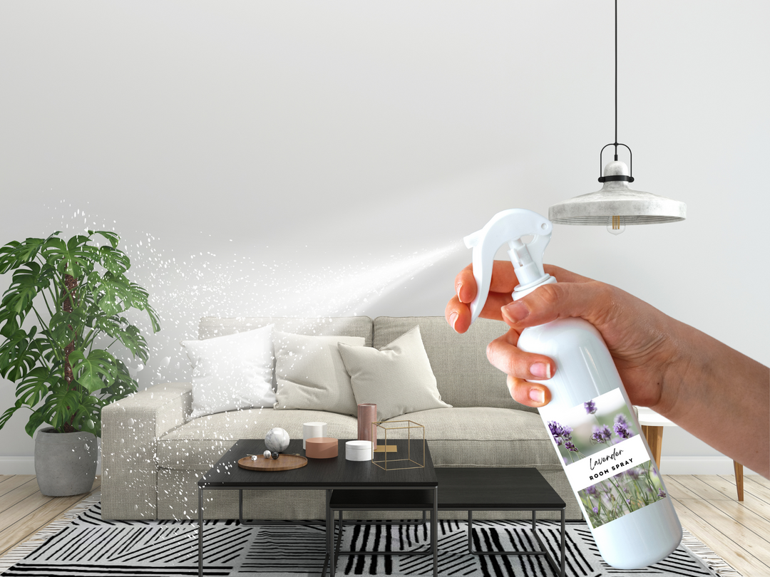 Hand spraying mist from a white room spray bottle in a bright living room