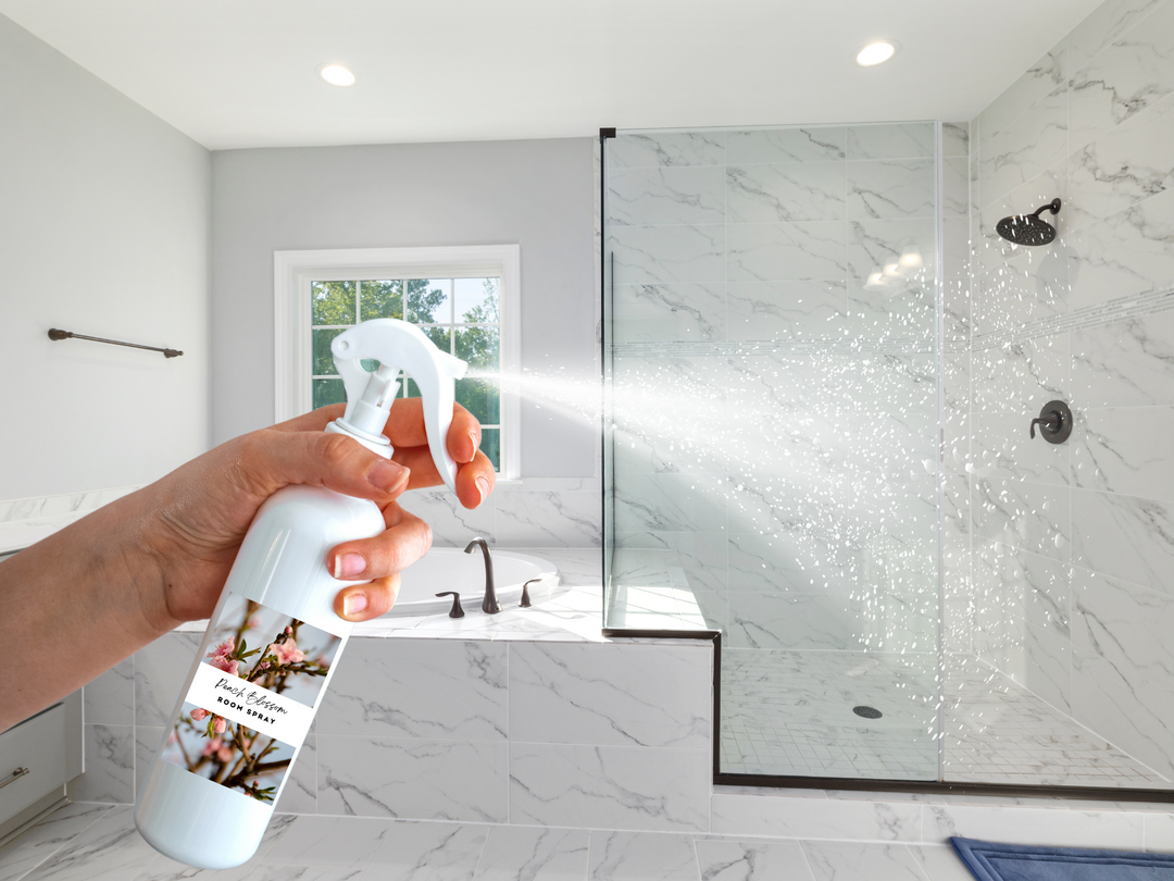 White room spray bottle with trigger nozzle spraying mist in a modern bathroom
