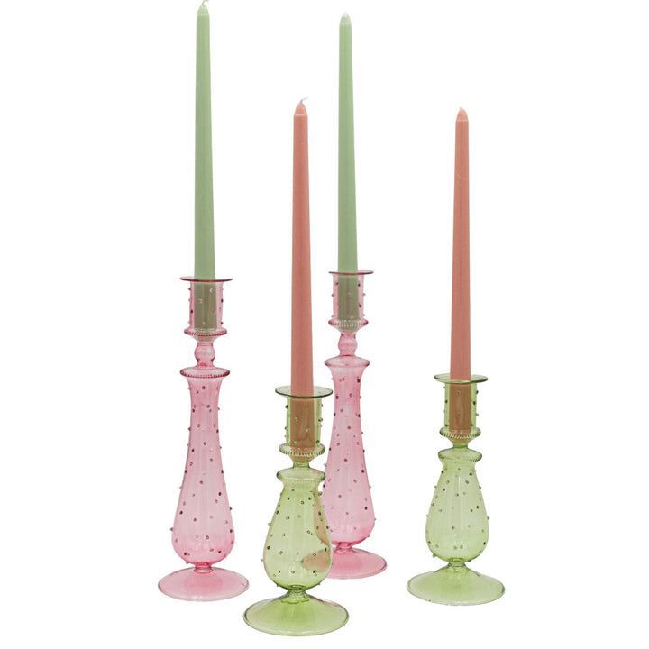 Tall green and pink dotted glass candle holders with open tops and visible candles.