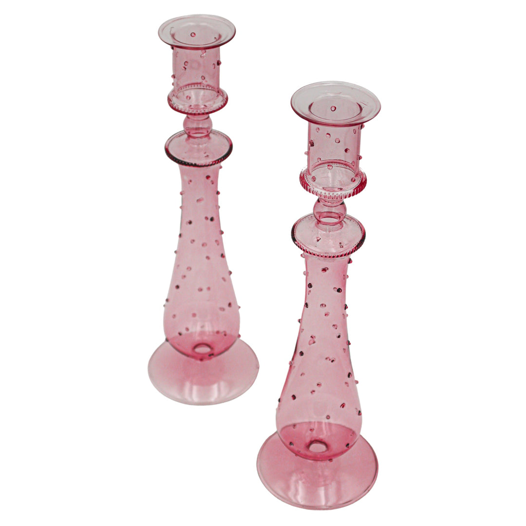 Pair of pink dotted glass candle holders with round caps and flared round bases.
