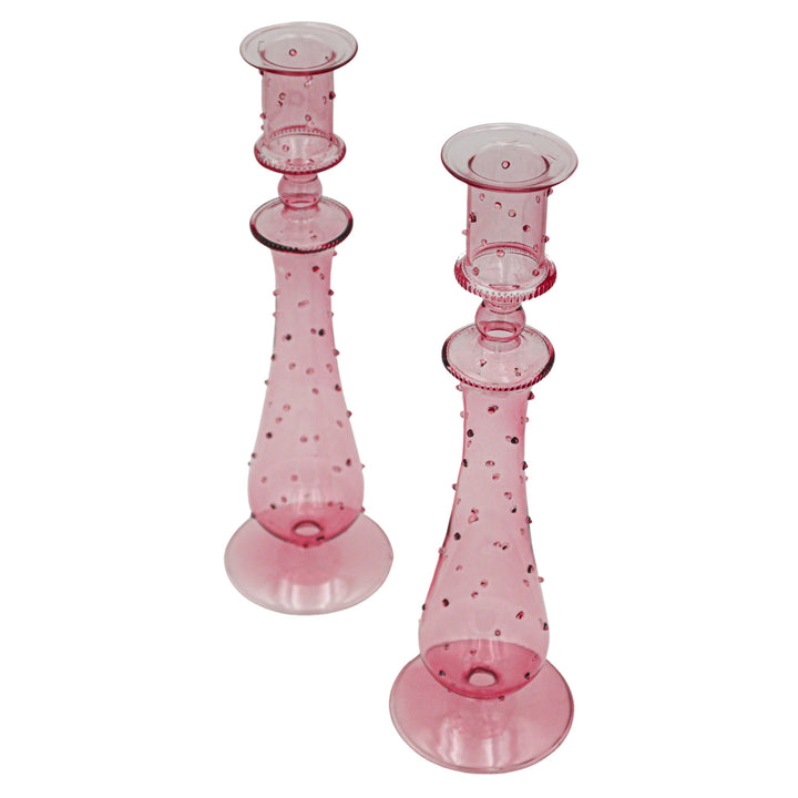 Pair of pink dotted glass candle holders with round caps and flared round bases.
