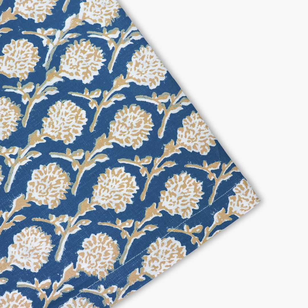Linen runner corner detail in ink blue with gold floral blocks and vine lines