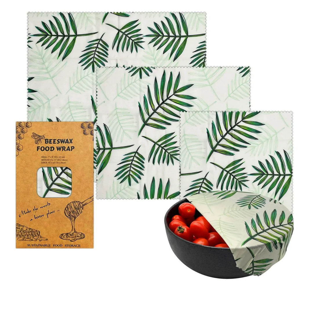Beeswax food wrap set, white cloth with green palm-leaf pattern, folded in a bowl
