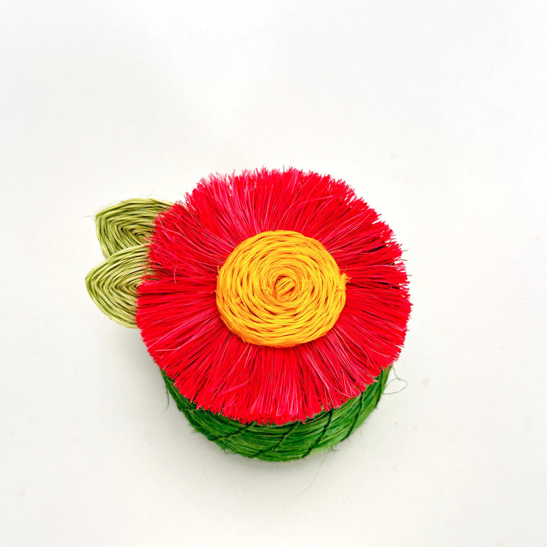 Tiny woven basket with green sides, red fringed flower lid, and yellow rosette center.