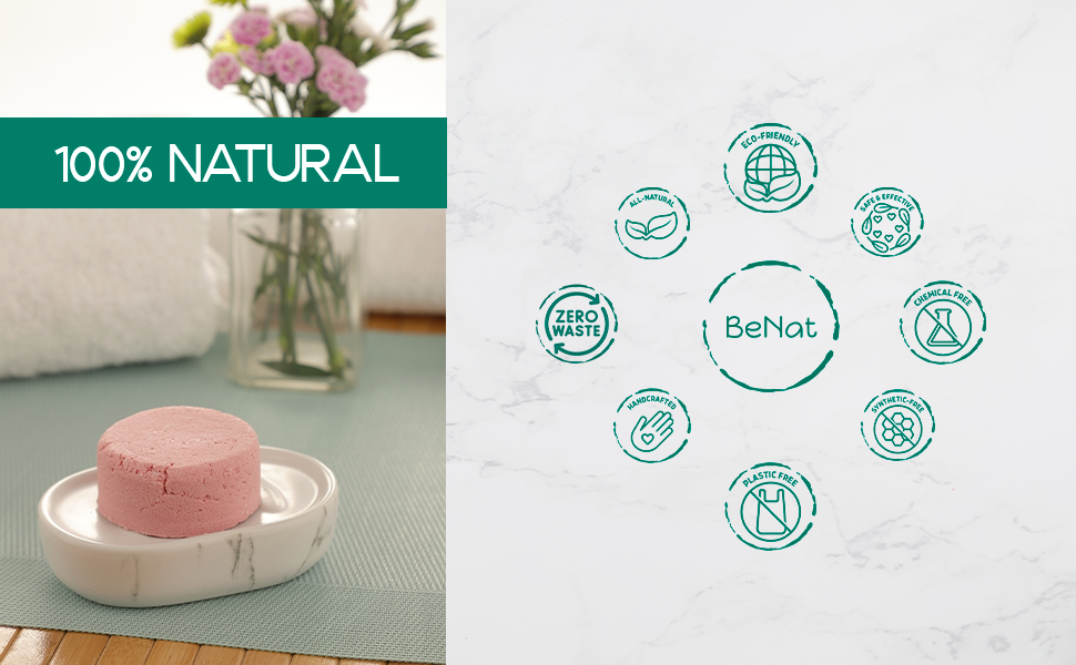 Round pink shampoo bar on a small dish with fresh flowers nearby