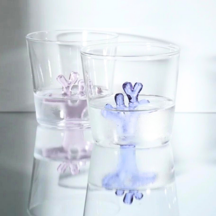 Water tumbler with clear glass and light pink and blue coral-shaped silicone insert