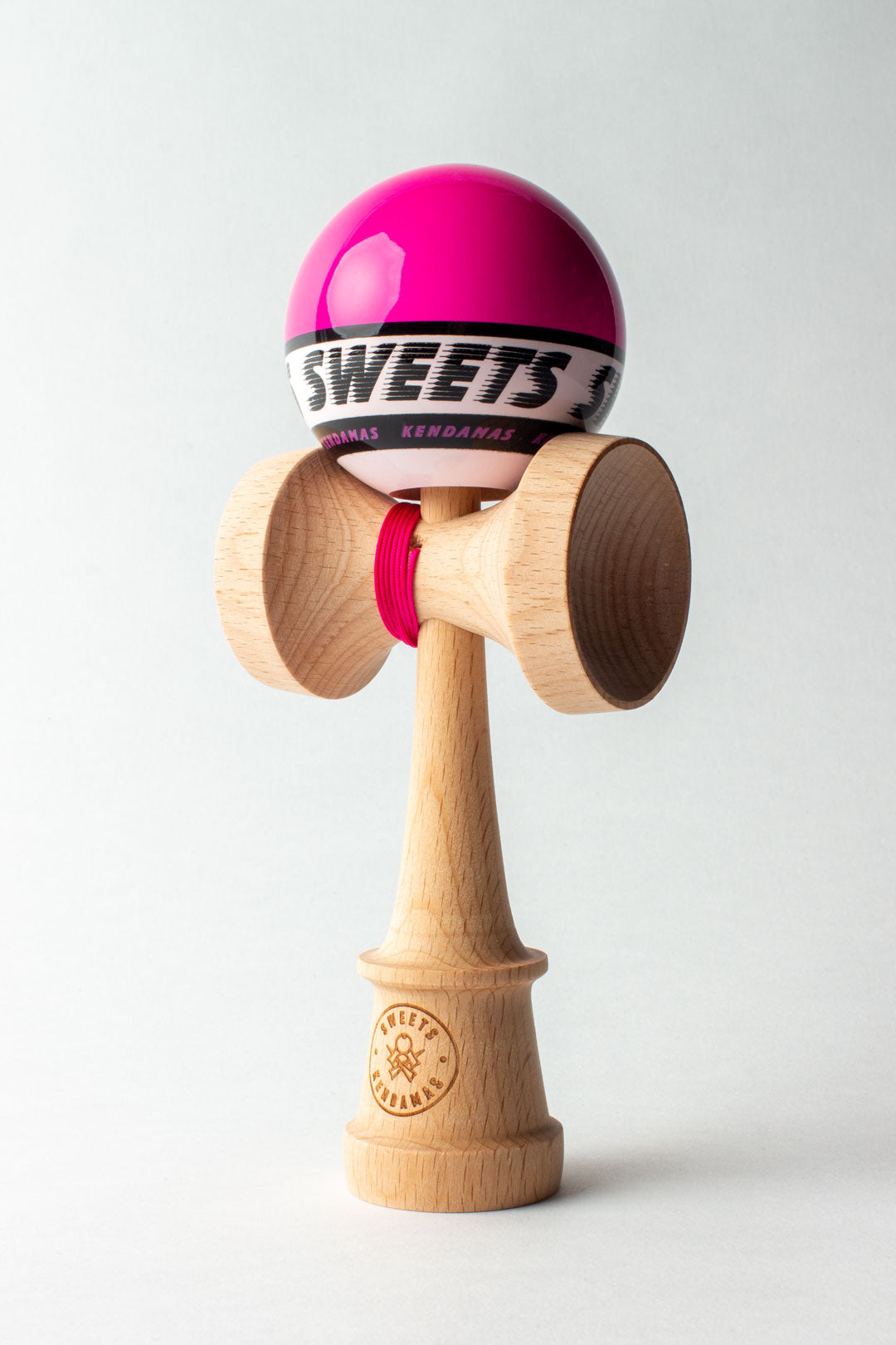 Wooden kendama with pink ball and red string, full figure front