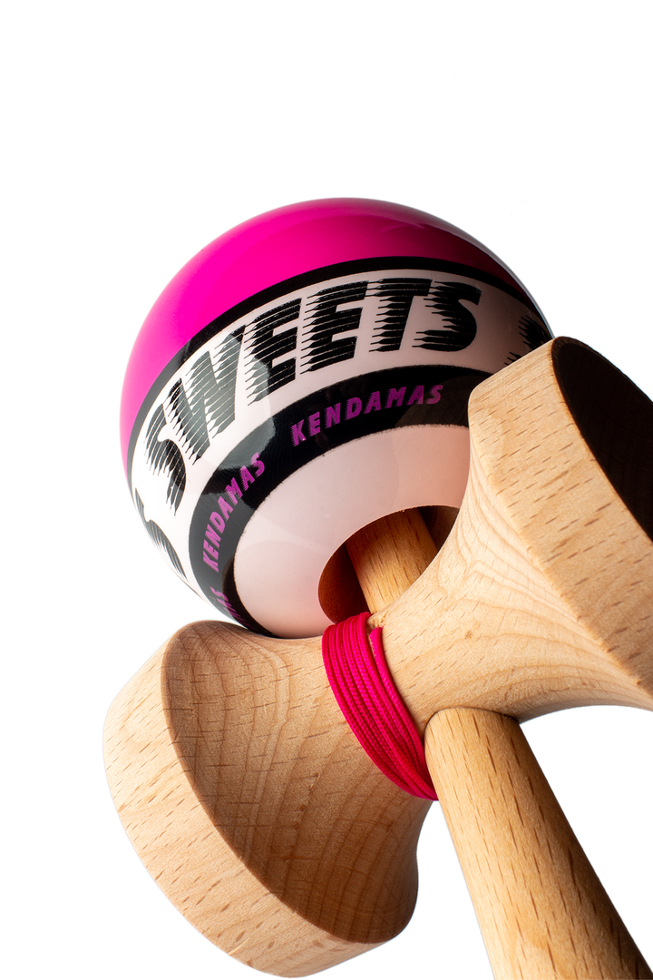 Wooden kendama with pink ball and black logo band, shown from side