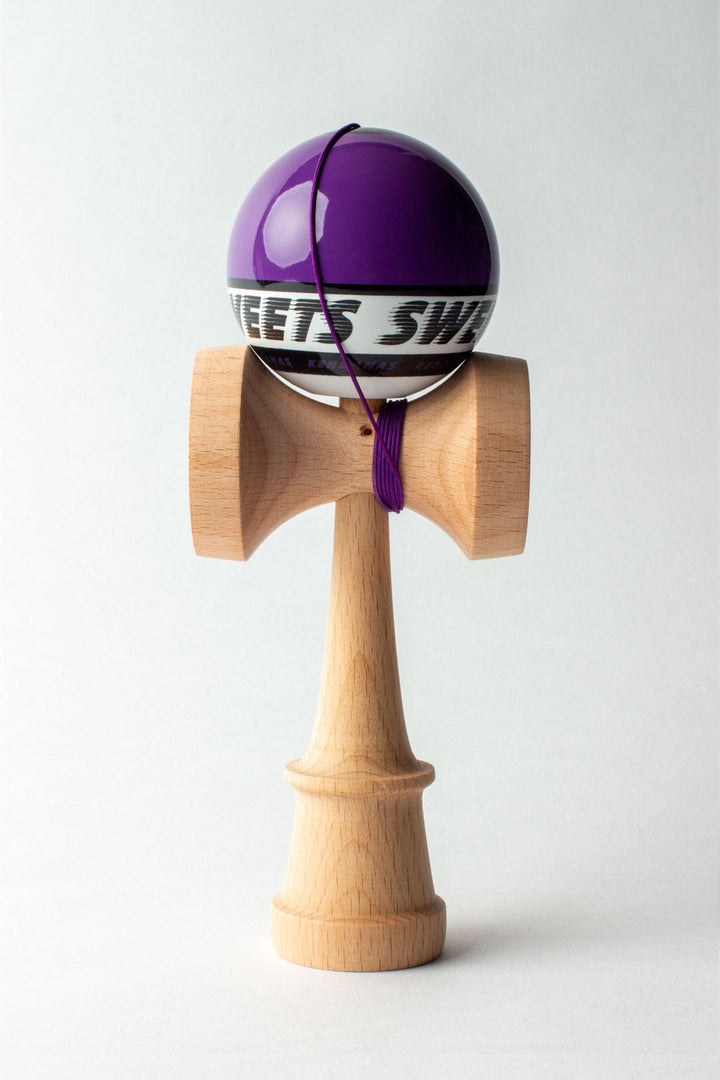 Wooden kendama with purple top ball and purple string across the head