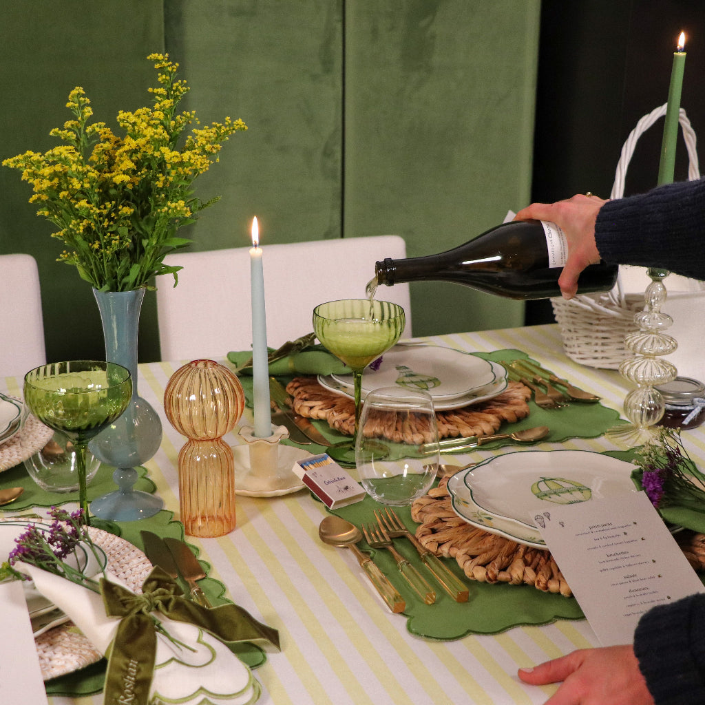 Ribbed sage-green coupe glass on event table centerpiece, with other glassware nearby.