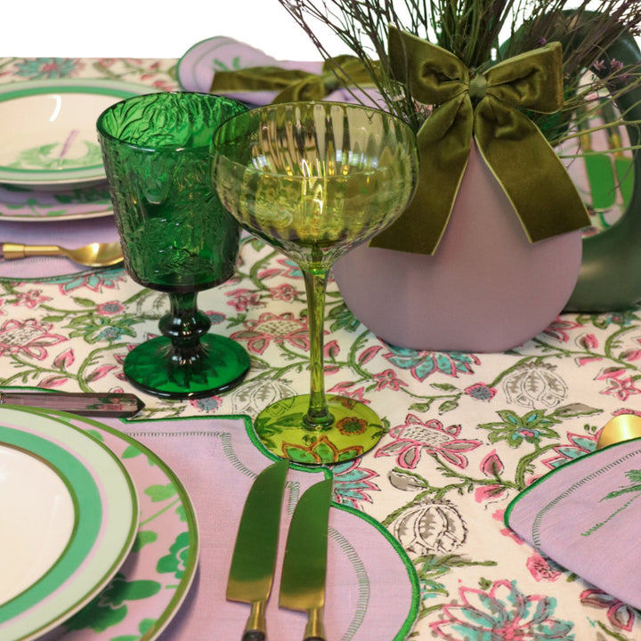 Green ribbed coupe glasses with short stem and flared bowl, two on table