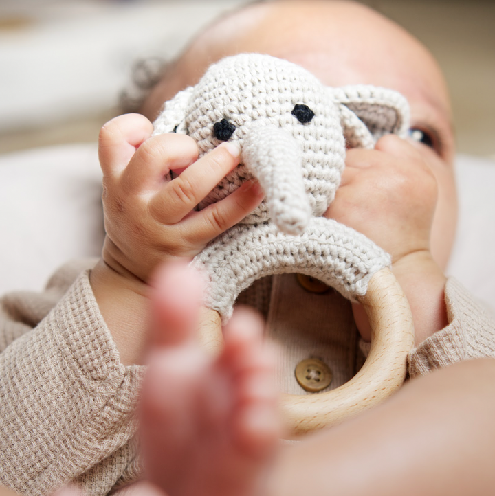 Grey elephant crochet rattle teether with black face and wooden ring, baby gripping handle