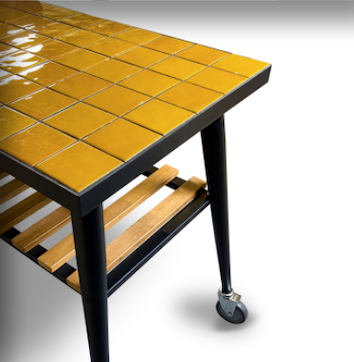 Outdoor grill cart with yellow tiled tabletop and lower storage grate on wheels
