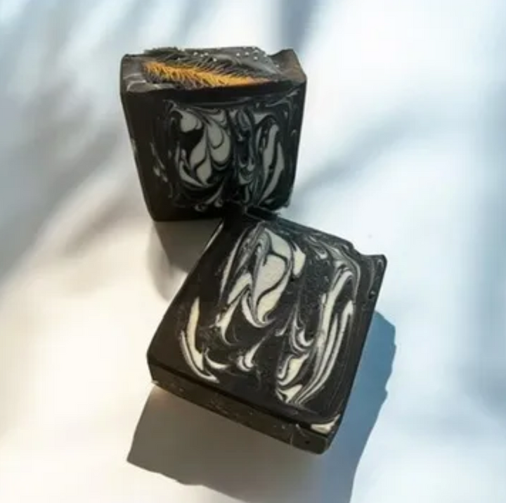 Set of two black handmade soaps with marbled white swirls and amber design