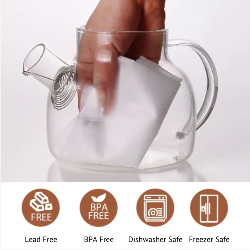 Glass tea steeper with bamboo-style lid being lifted by a hand