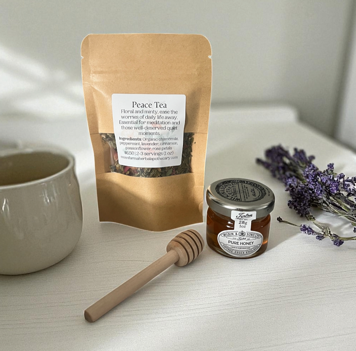 Wellness set with peace tea pouch, honey jar, and wooden honey dipper