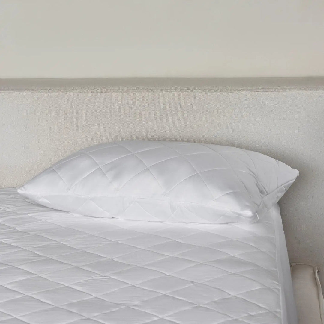 Light-colored bamboo pillow protector with quilted channels, smooth cover