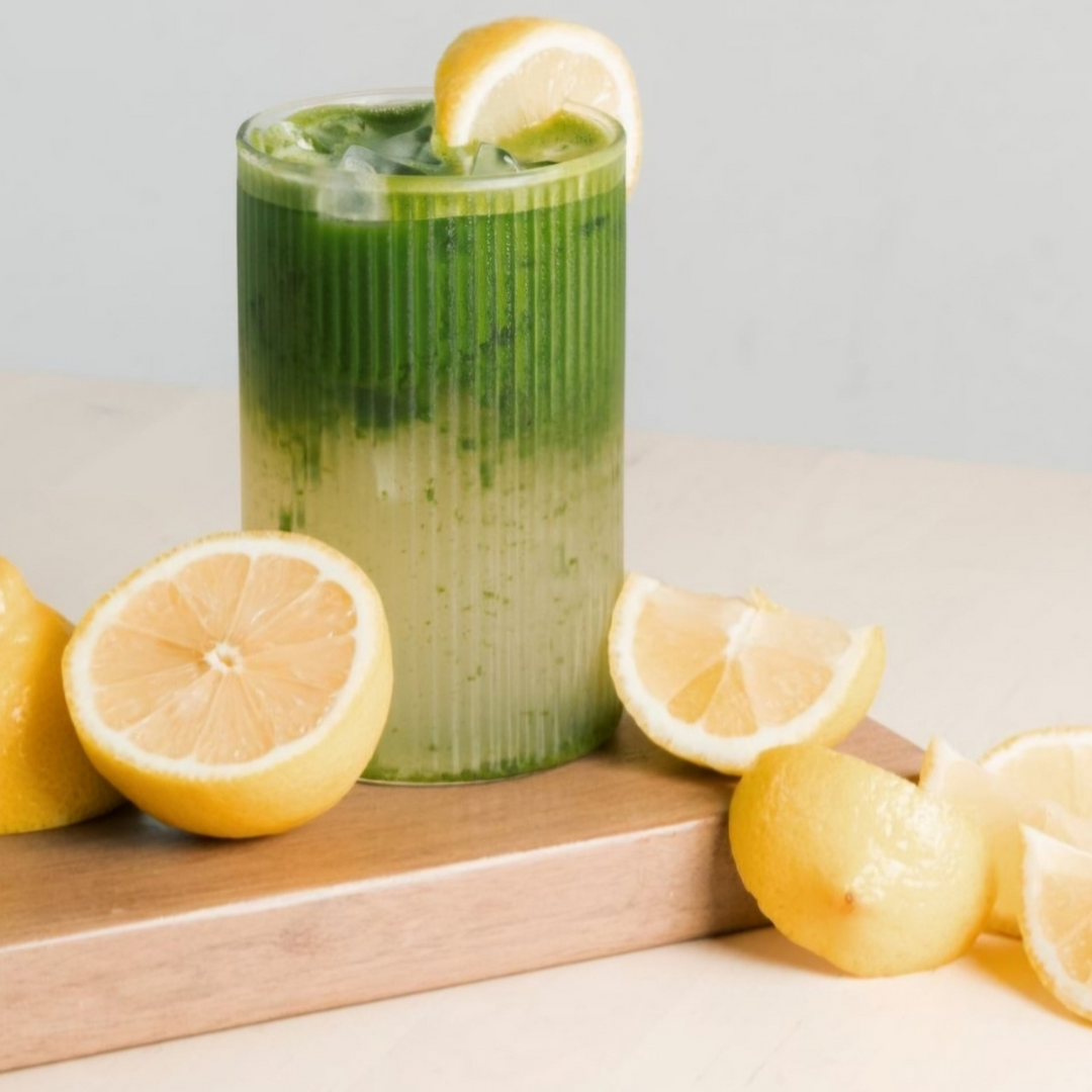 Iced green matcha drink in a tall glass with lemon slices