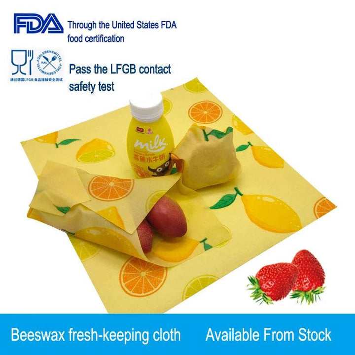 Beeswax food wrap, yellow cloth with fruit prints, wrapped around containers