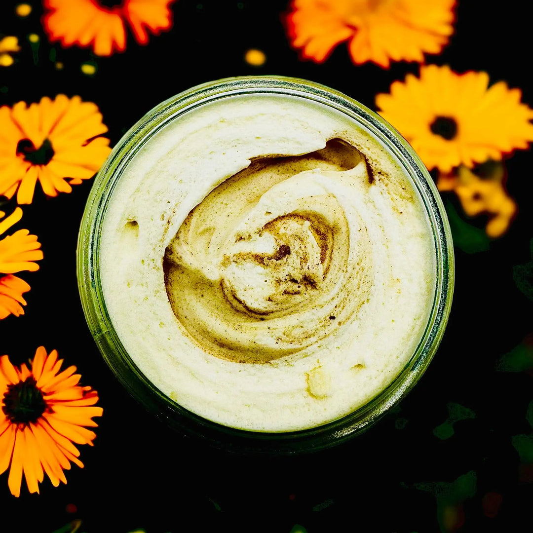 Open jar top with pale yellow mango butter swirl, seen from above
