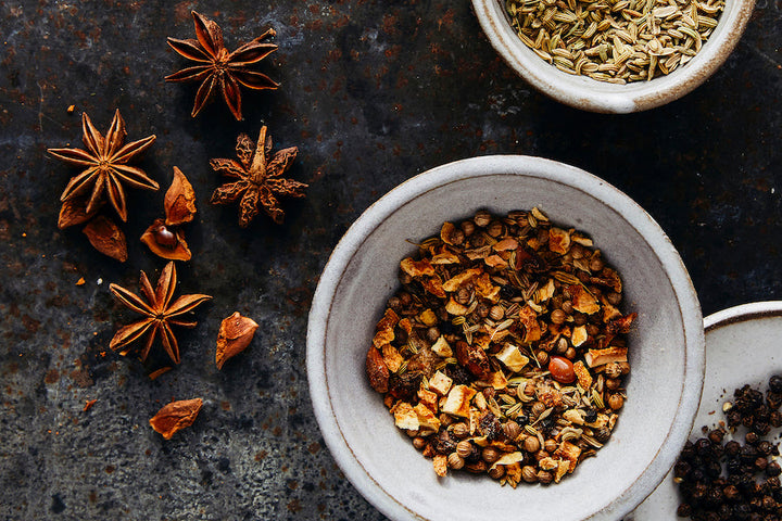 Salmon rub seasoning blend in a small ceramic bowl with scattered dried spices