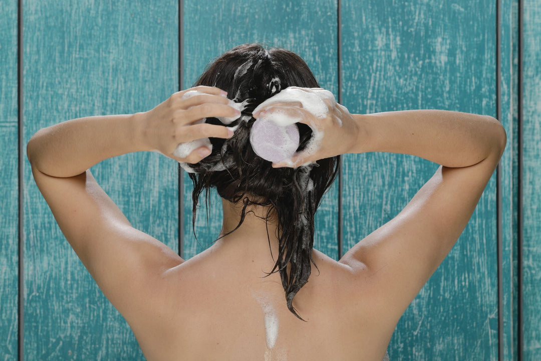 Shampoo lather on wet hair, hands massaging scalp during wash
