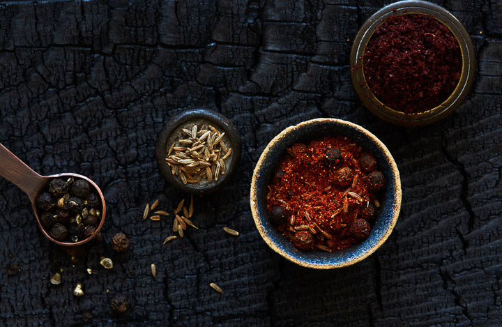 Bowls of shawarma spice mix with herbs and whole spices