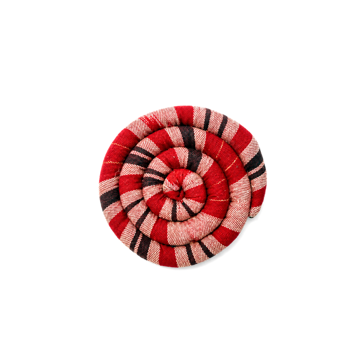 Round spiral trivet with red and tan plaid stripes and stitched rosette center