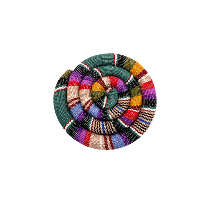 Round spiral trivet with green, red, purple, and tan plaid stripes and stitched rosette center