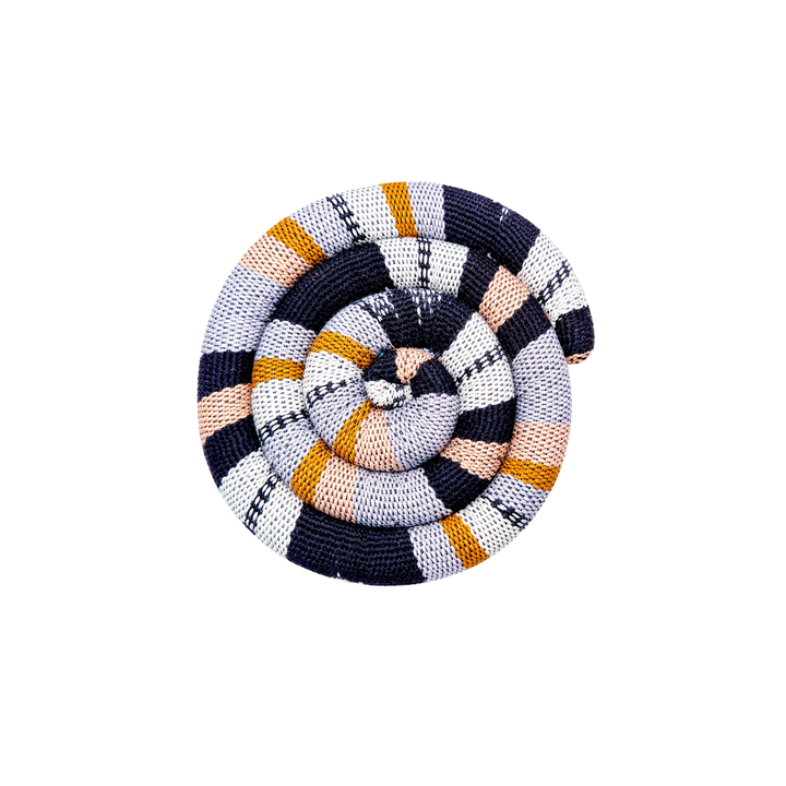 Round spiral trivet with navy and cream plaid stripes, orange stripe accents, and rosette center