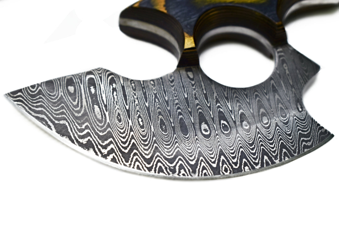 Ulu-style blade close-up with wavy damascus steel edge and curved black handle