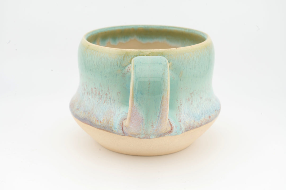Ceramic wide mug with turquoise glaze, front view showing spout-like center ridge