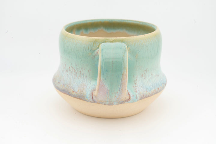 Ceramic wide mug with turquoise glaze, front view showing spout-like center ridge