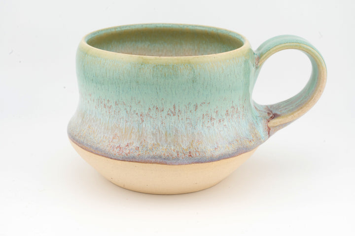 Ceramic wide mug with turquoise glaze, rounded handle, and speckled textured finish