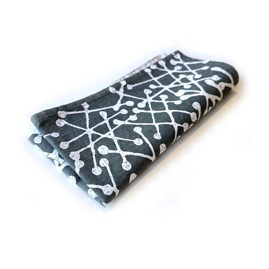 Folded dark gray napkin with white line-and-dot pattern