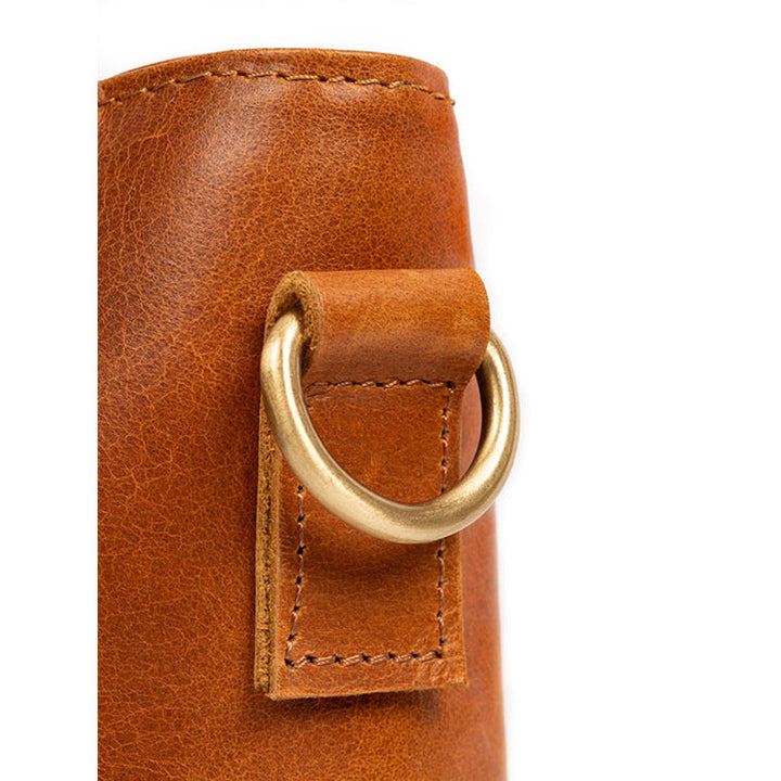 Tan leather tote bag front close-up with metal D-ring and stitched tab