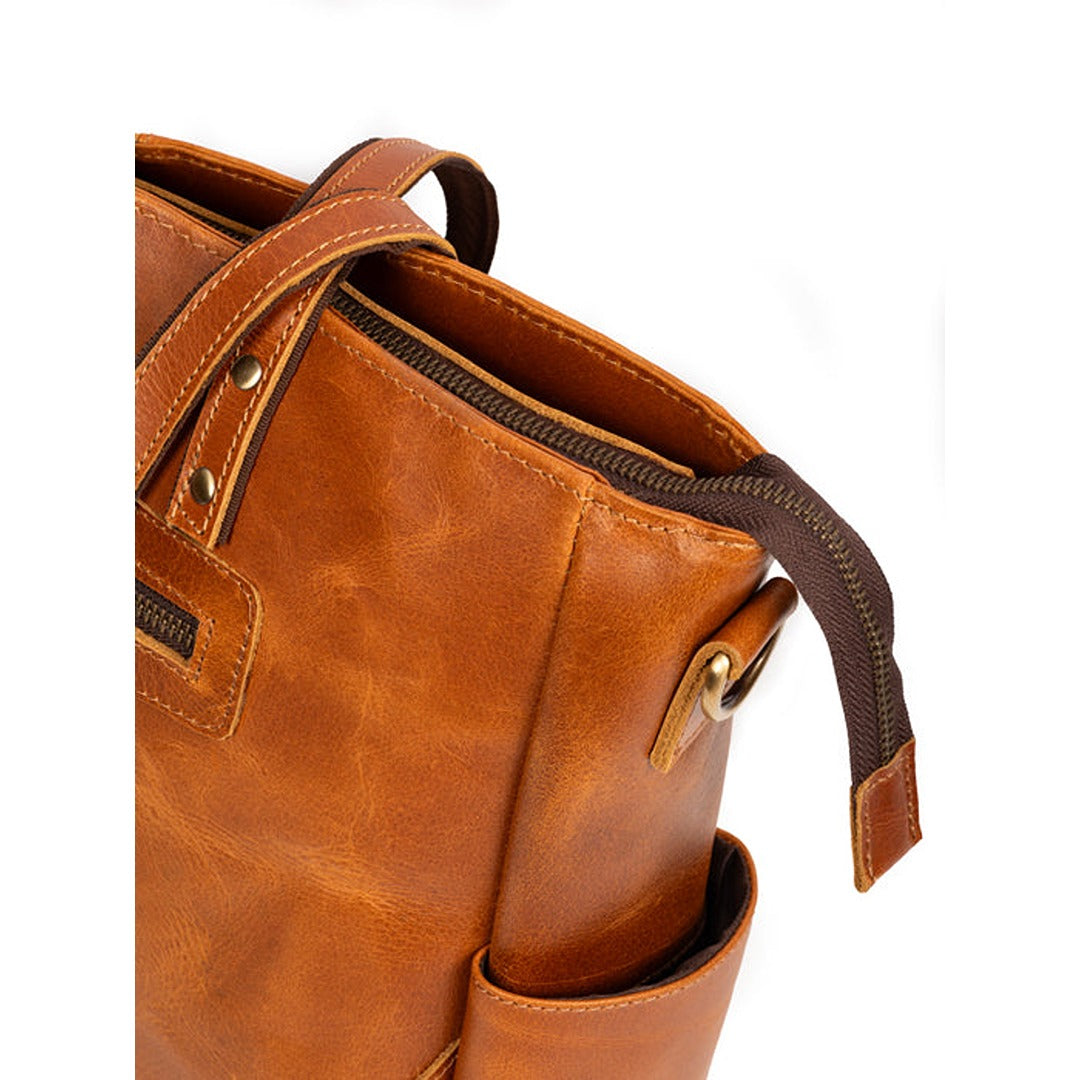 Tan leather tote bag side view with zip pocket edge and shoulder strap hardware