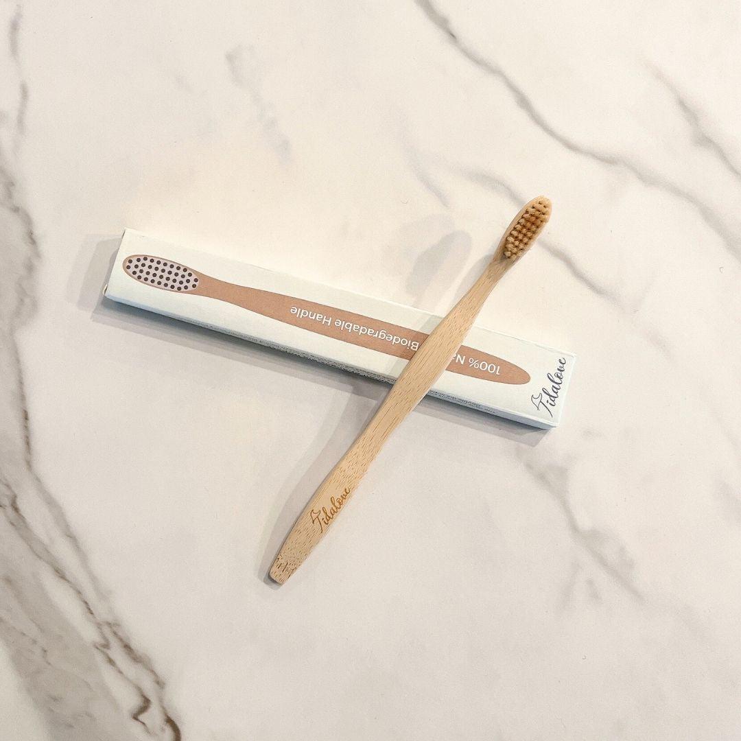 Bamboo toothbrushes with bristle ends, each in a protective sleeve for twin set