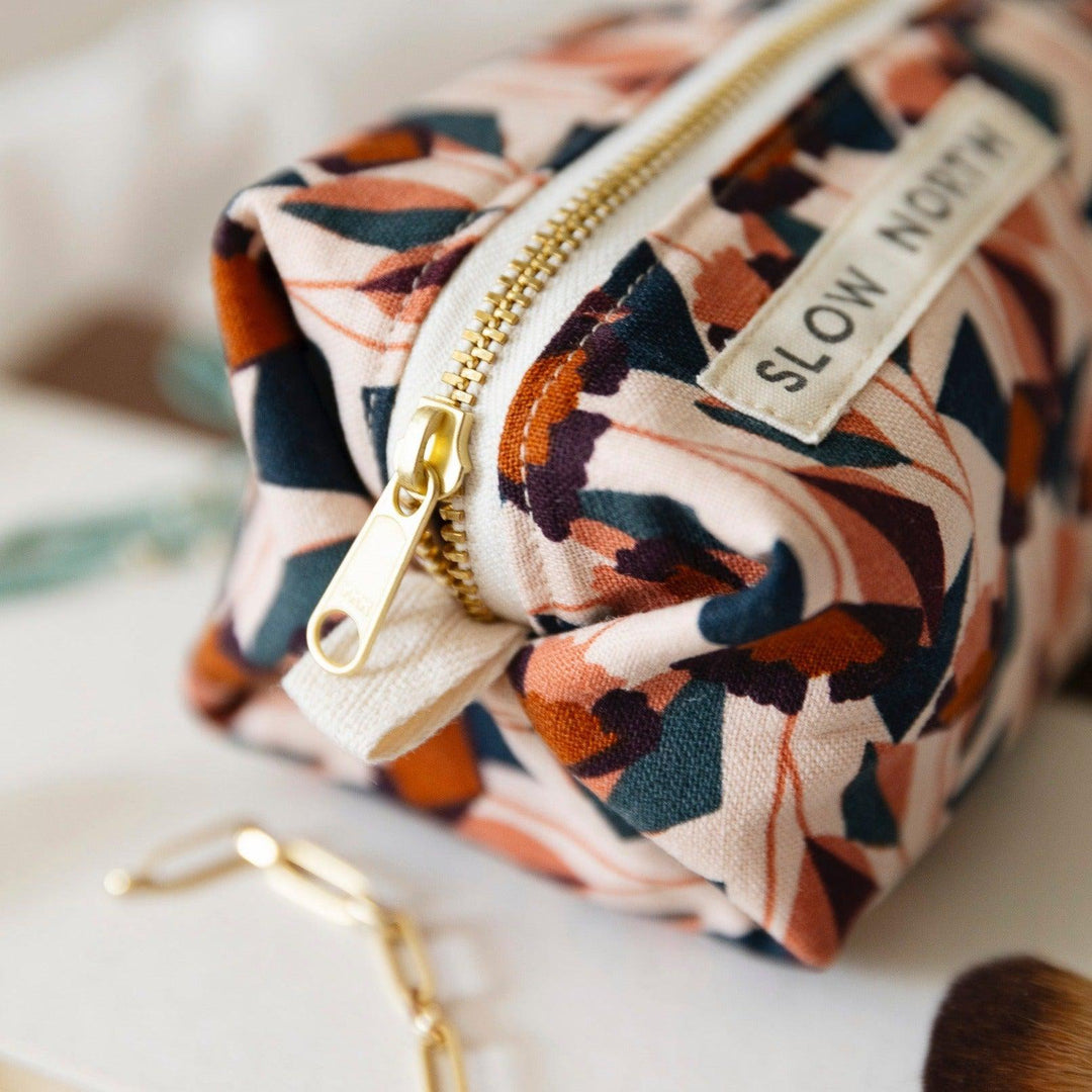 Close-up of geometric travel pouch zipper and “SLOW NORTH” label