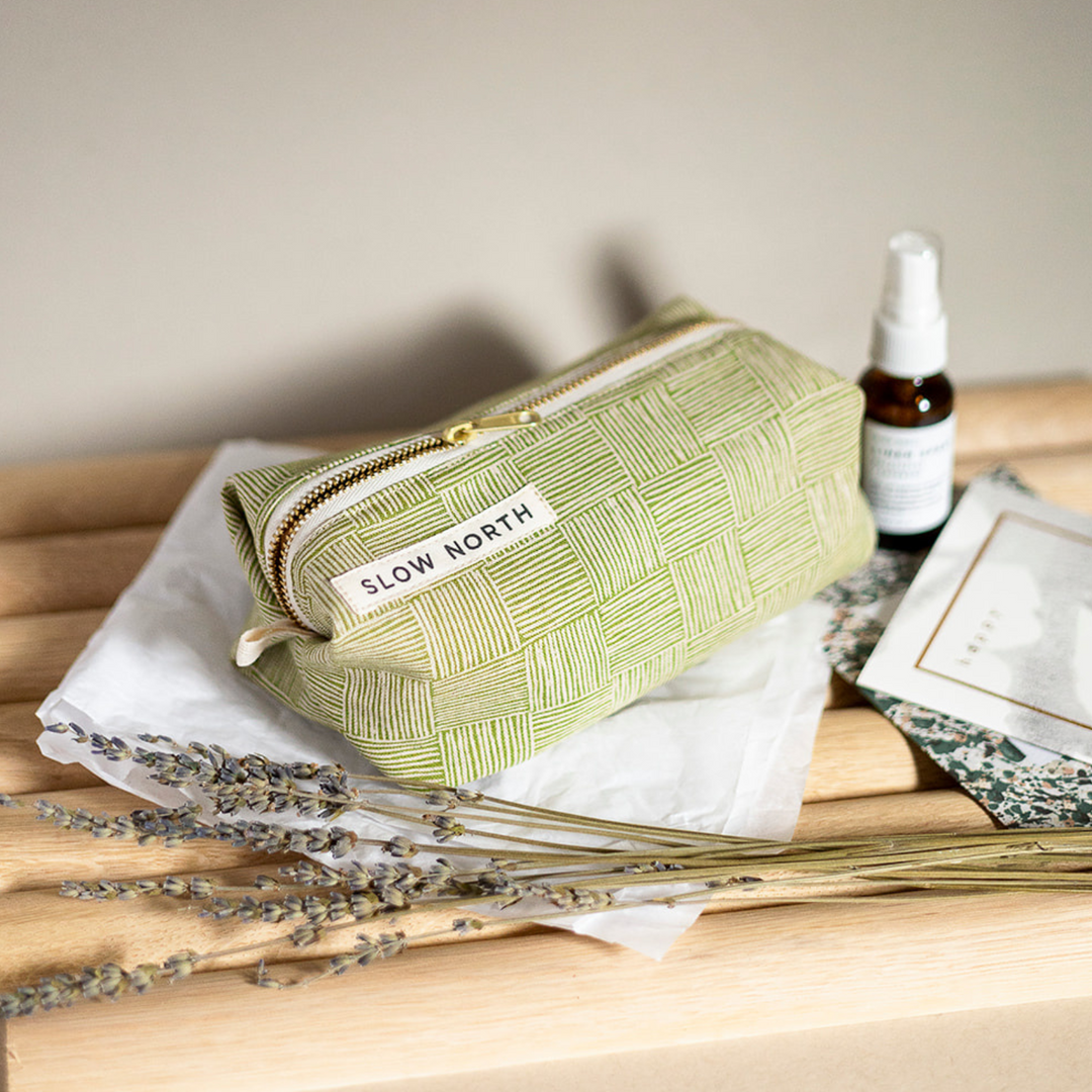 Green woven travel pouch with zip top and SLOW NORTH patch