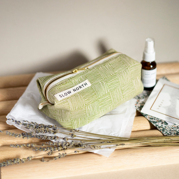 Green woven travel pouch with zip top and SLOW NORTH patch