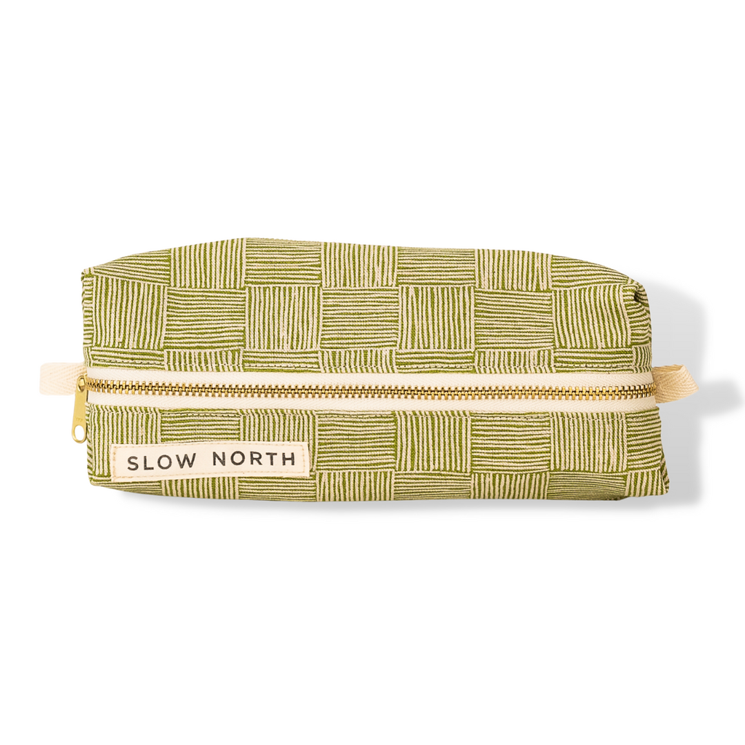 Green patterned travel pouch with top zipper and SLOW NORTH label