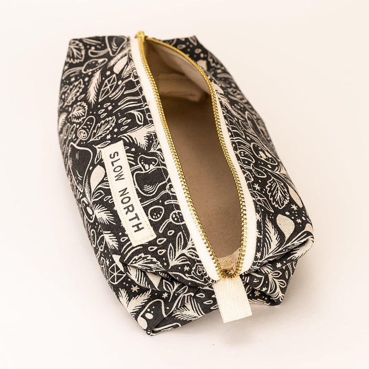 Black printed travel pouch open view with gold zipper, tan tassel pull