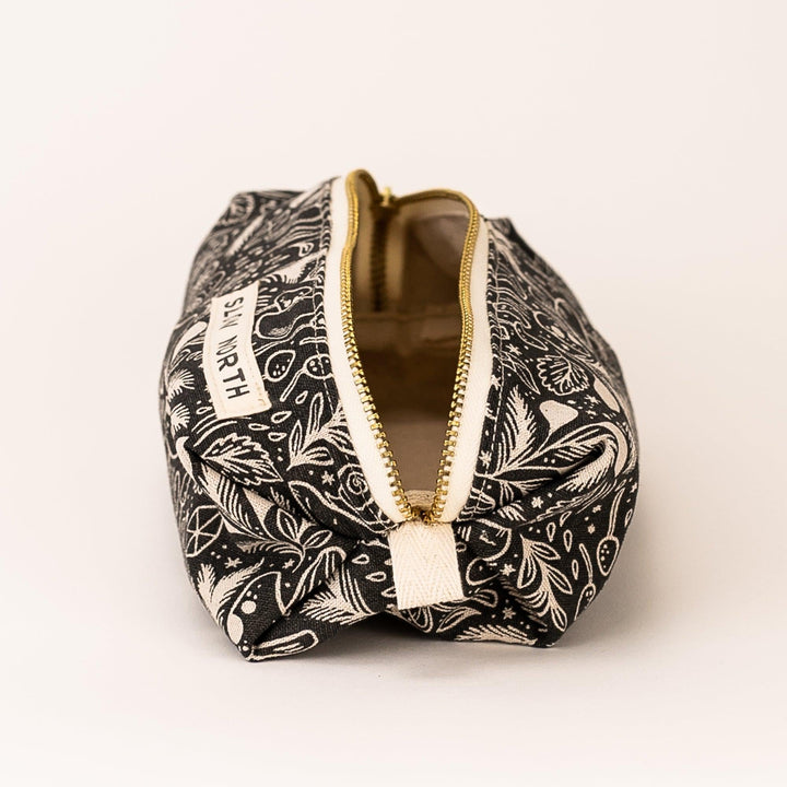 Small black printed pouch open top with gold trim and “SLOW NORTH” tag