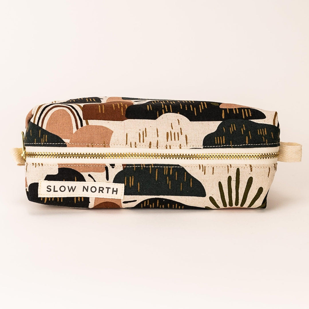 Zipper pouch with desert-pattern fabric in tan, black, and cream; flat front view