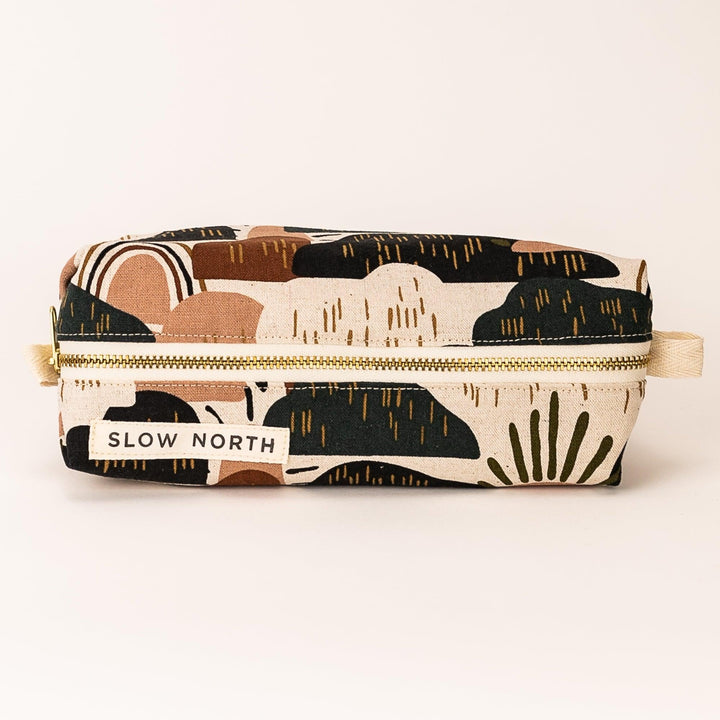 Zipper pouch with desert-pattern fabric in tan, black, and cream; flat front view