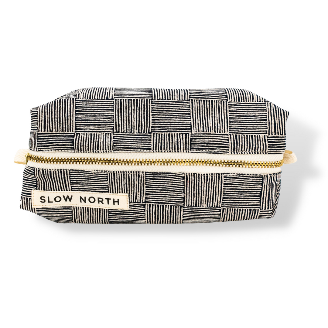 Black-and-white patterned travel pouch, gold zipper, SLOW NORTH label